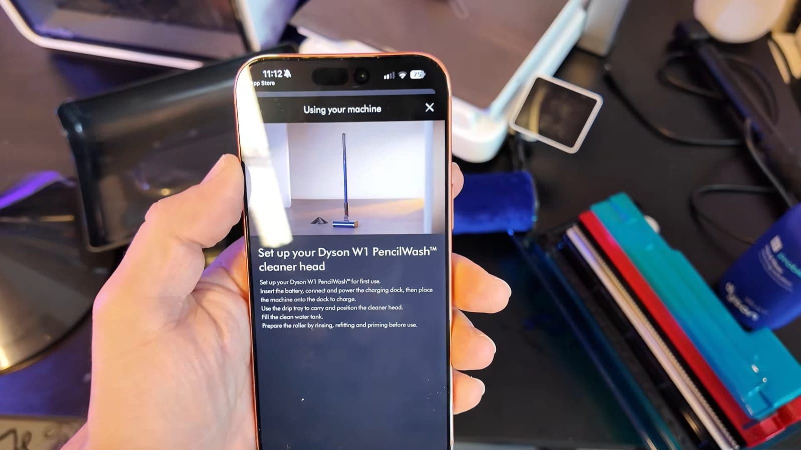 Hand met smartphone die in de MyDyson-app de instructies voor het opzetten van de W1 PencilWash toont