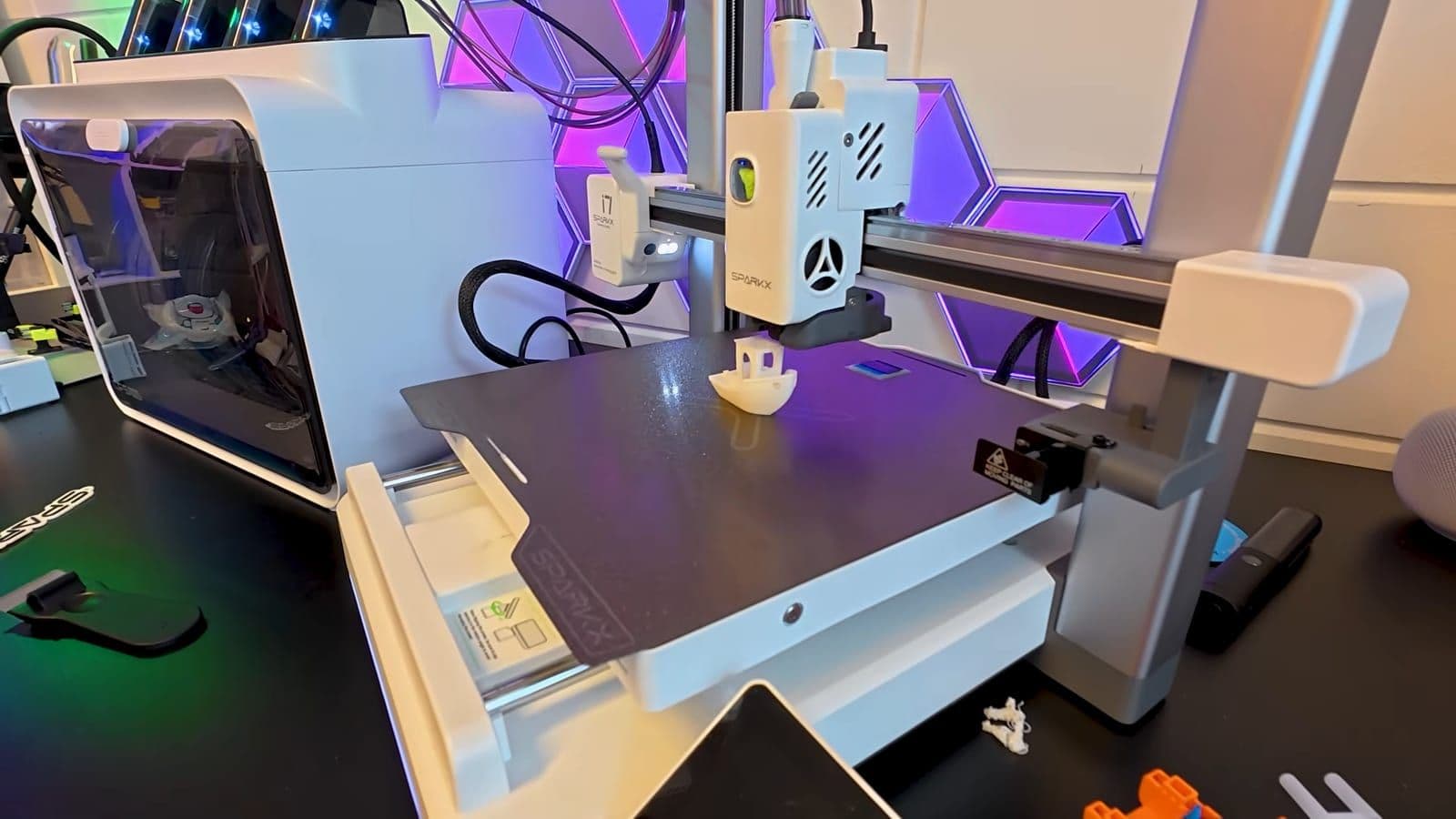 Detailopname van de printkop die het eerste witte Benchy testbootje opbouwt op de PEI-plaat
