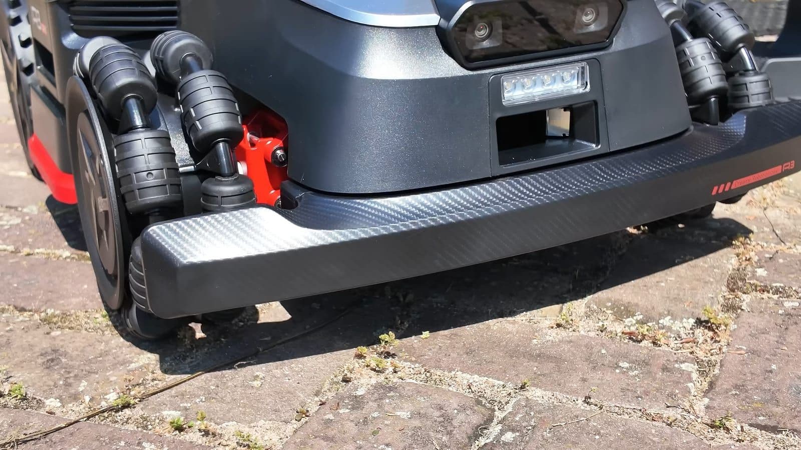 De voorzijde van de robotmaaier met carbonlook bumper en speciale omnidirectionele wielen