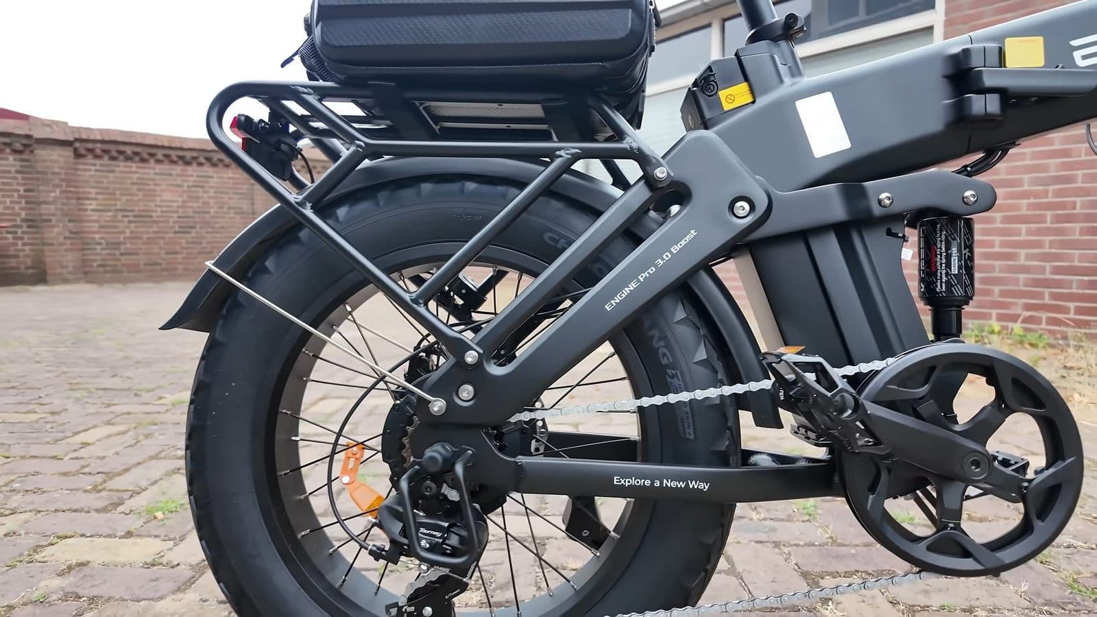 Zijaanzicht van de achterbrug met derailleur, cassette en de achterdemper