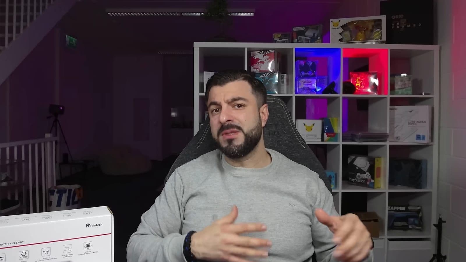 Zino talking about home cinema cable management in front of studio shelves