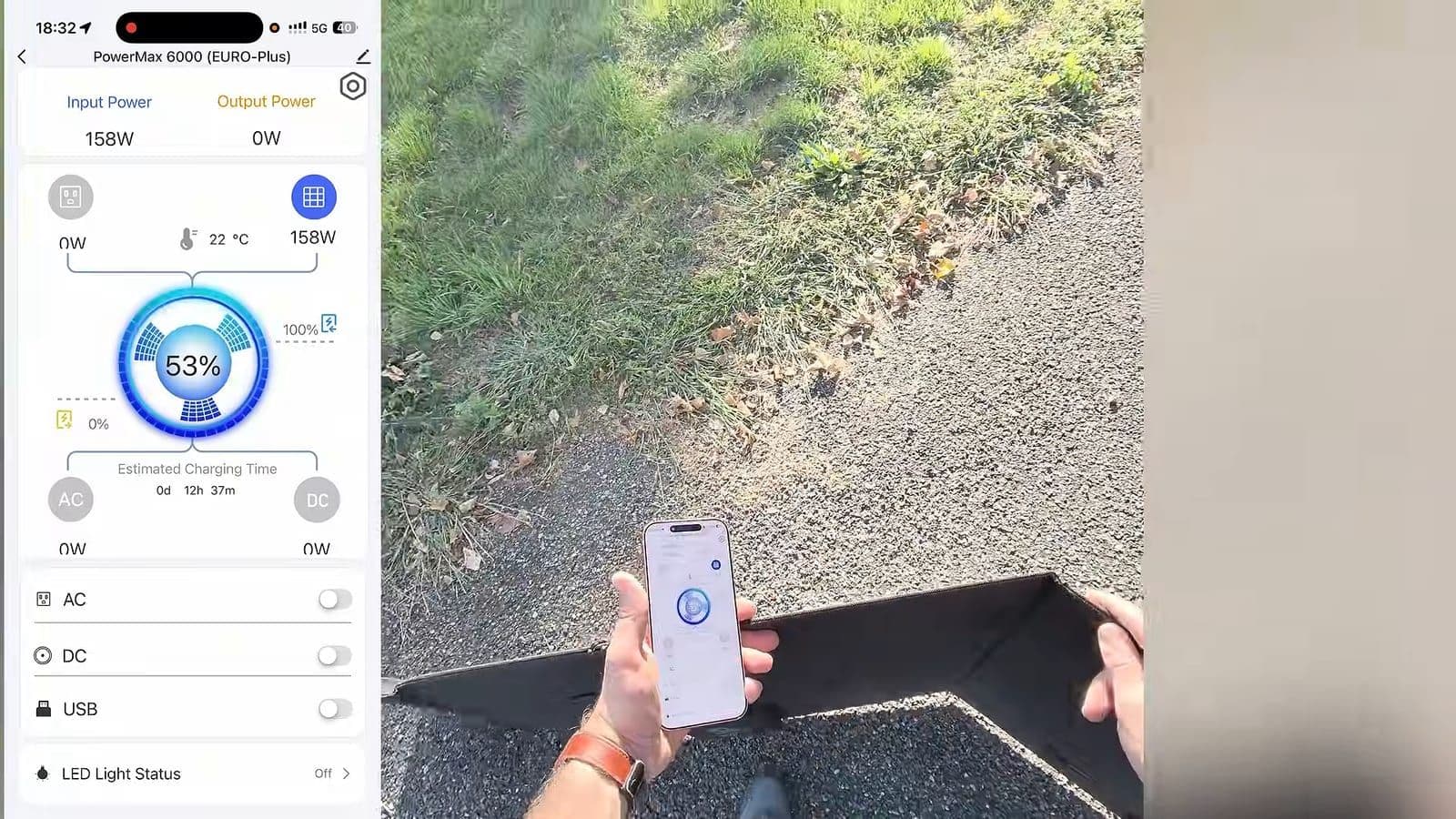 Hand met smartphone met de Oscal-app naast een zonnepaneel op grind en gras