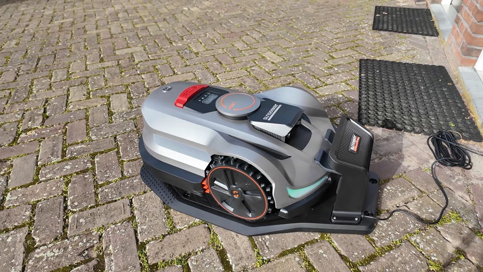 Sunseeker Elite X7 Gen 2 op het laadstation op klinkerbestrating