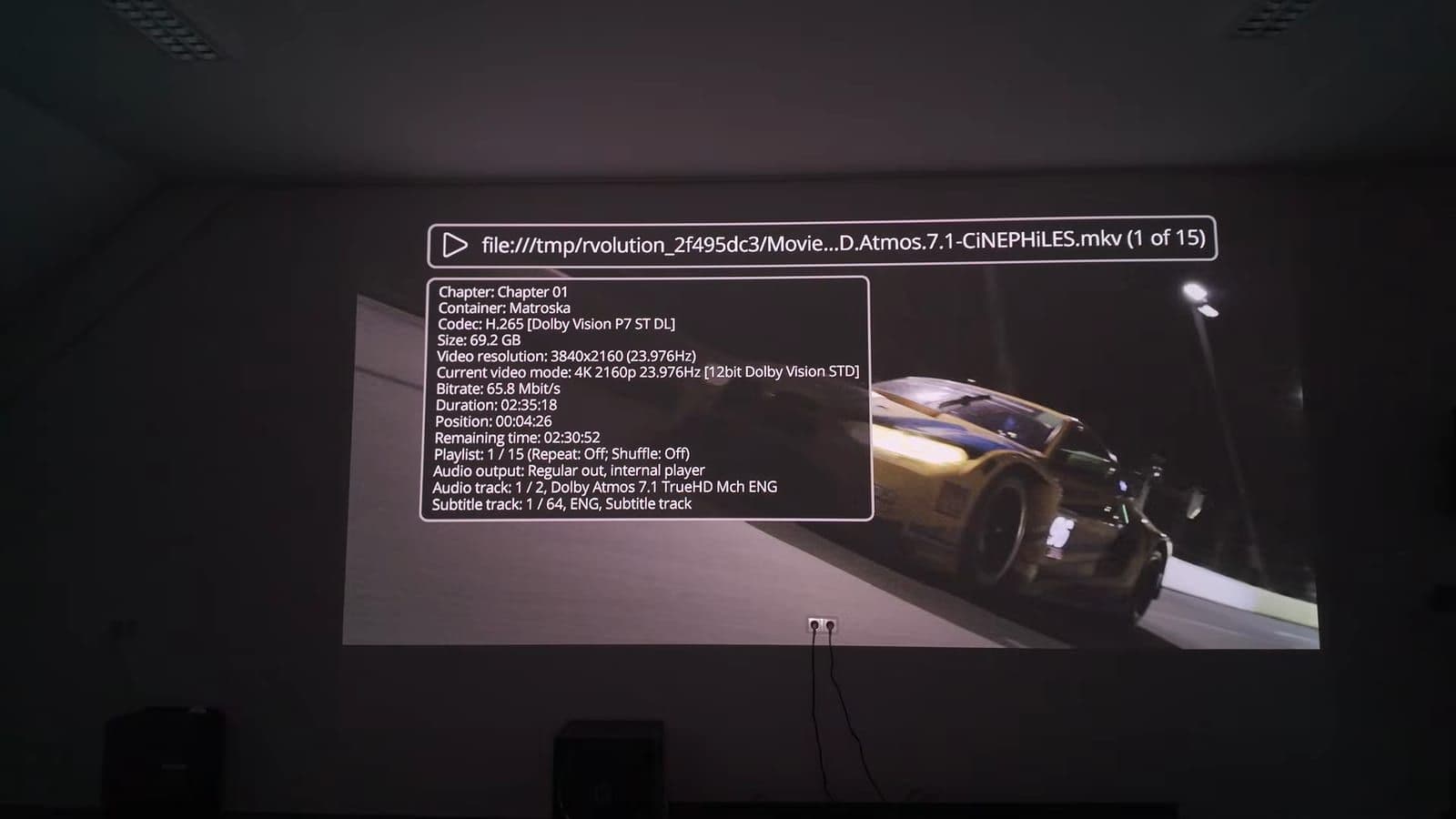 F1 racing movie projected on the white wall with the Iris control menu overlay